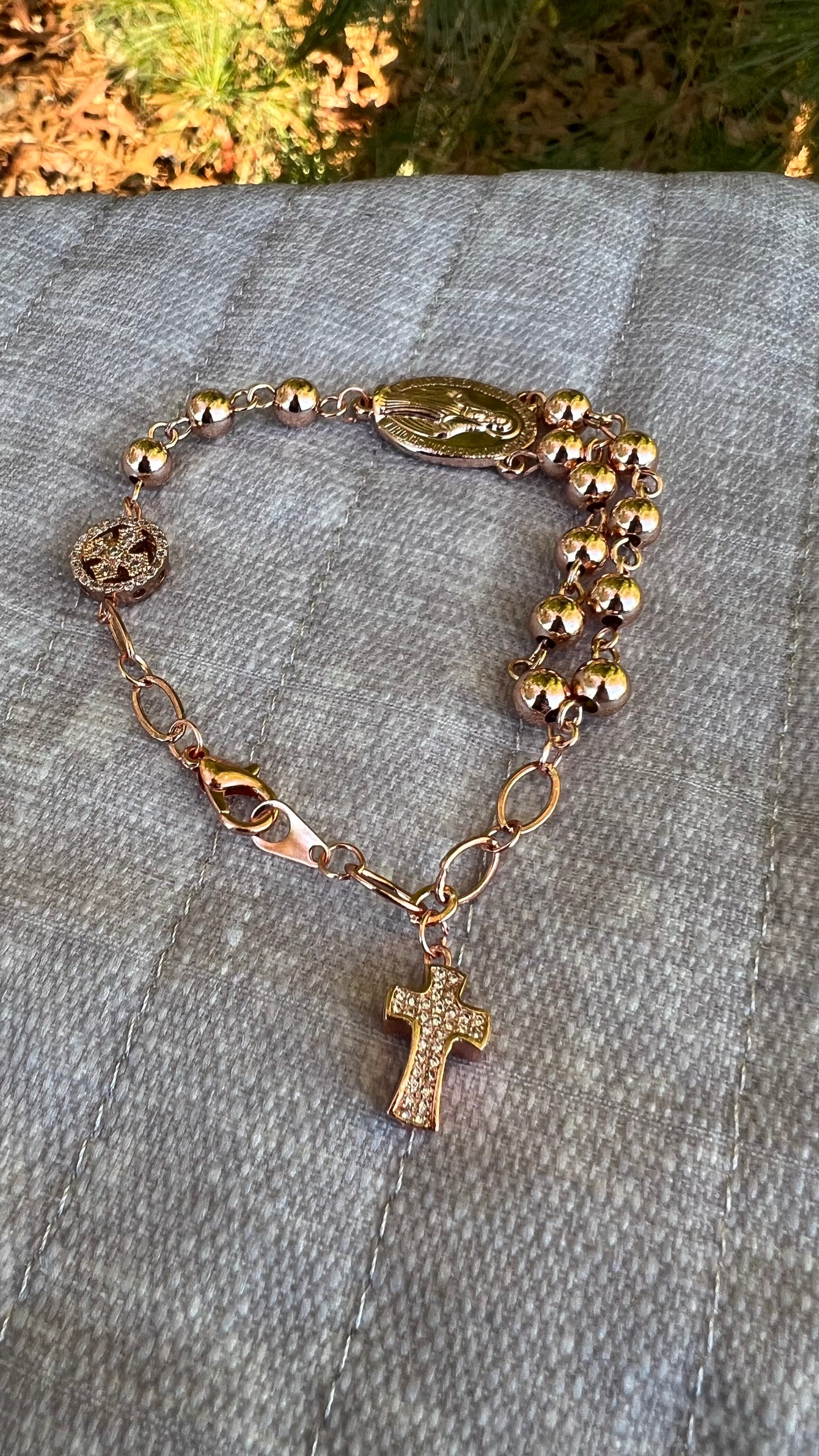 Faith-inspired Catholic bracelet with rose gold chain, crucifix charm, and detailed Marian centerpiece