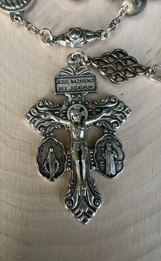 Front view of ornate Pardon Crucifix with “Jesus Nazarenus Rex Judaeorum,” flanked by Saint Benedict and Miraculous Medal symbols.