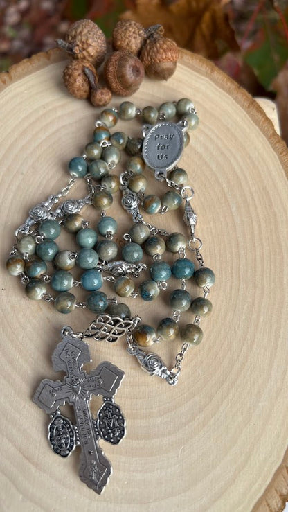 Catholic rosary honoring Saint Padre Pio, with round ceramic beads in green and brown tones and a detailed Italian crucifix centerpiece.
